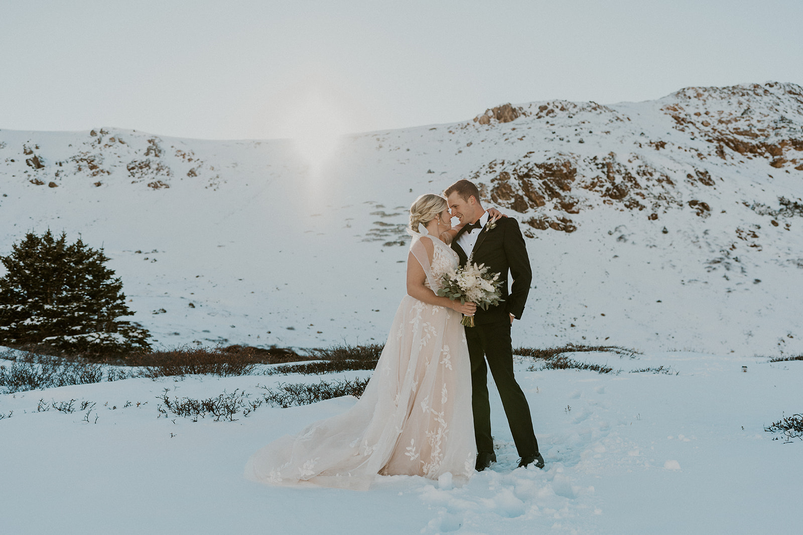 Newlyweds embrace nose to nose in the snow at their Loveland Pass Elopement