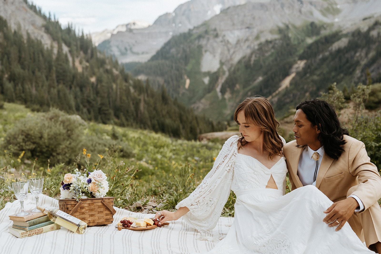 Newlyweds share a picnic of books, wine and cheese plate during their Ouray Elopement