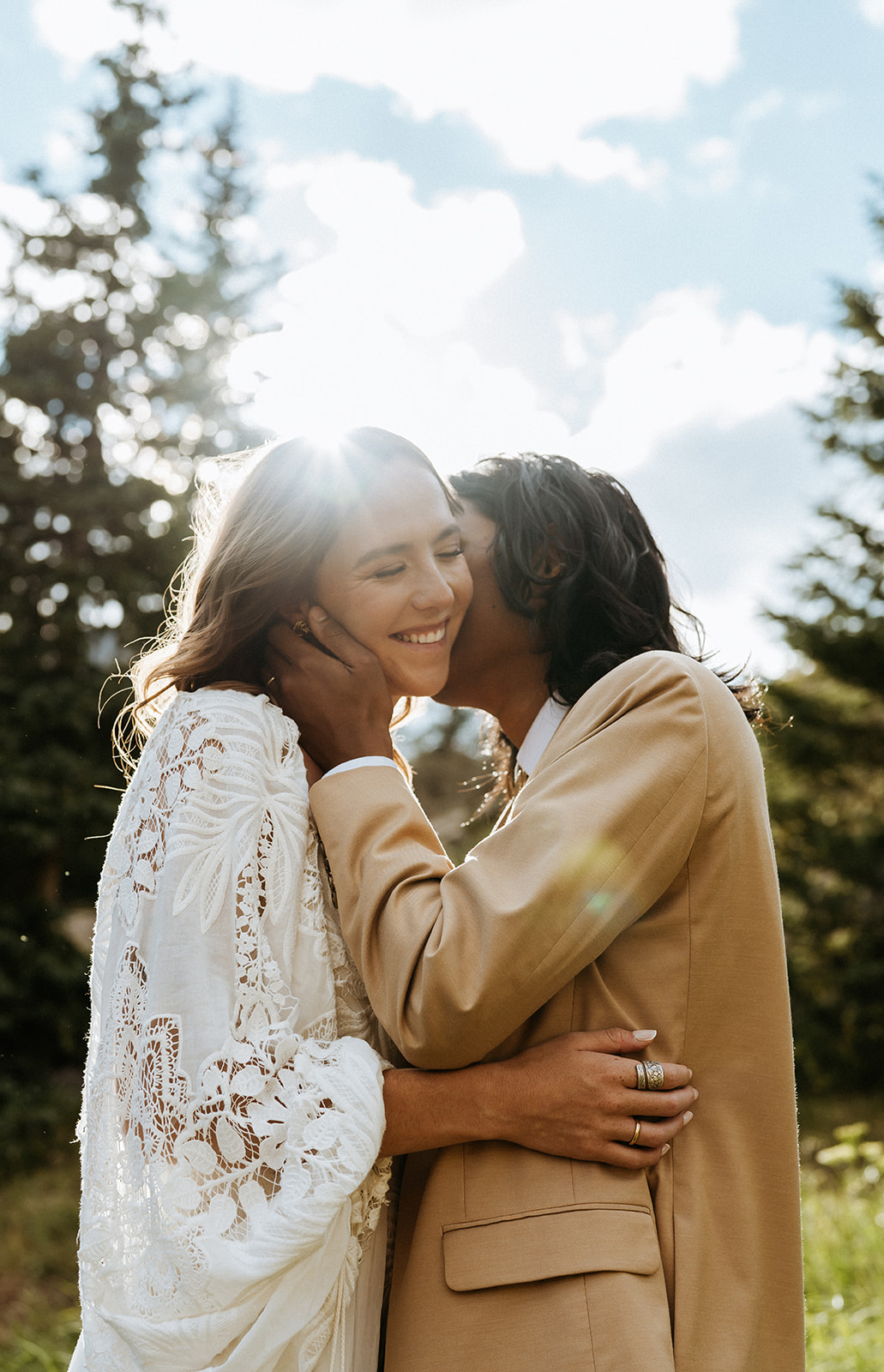 Newlyweds kiss and smile at sunset on a remote hillside at their Ouray Elopement