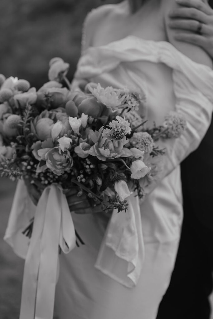 Black and white close up photo of a bride holding her wedding bouquet