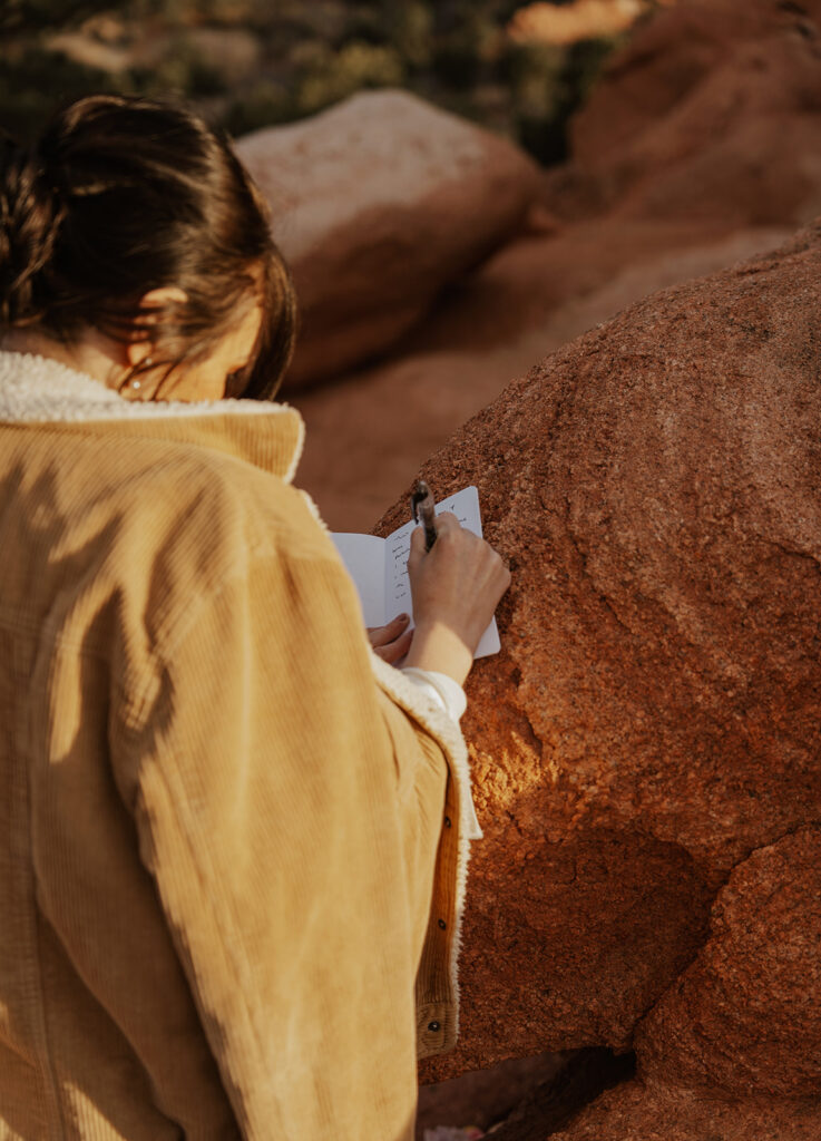 Bride wearing a coat as she writes her personal vows