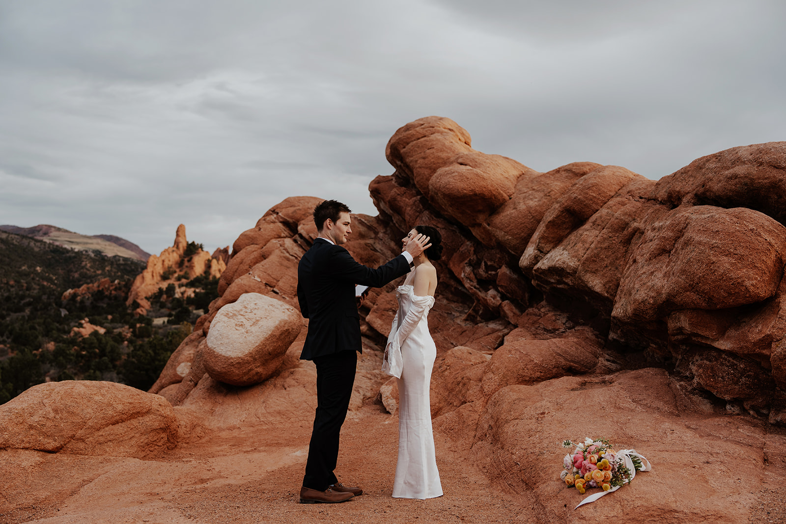 Groom brushing brides hair out of her face during their intimate vow reading