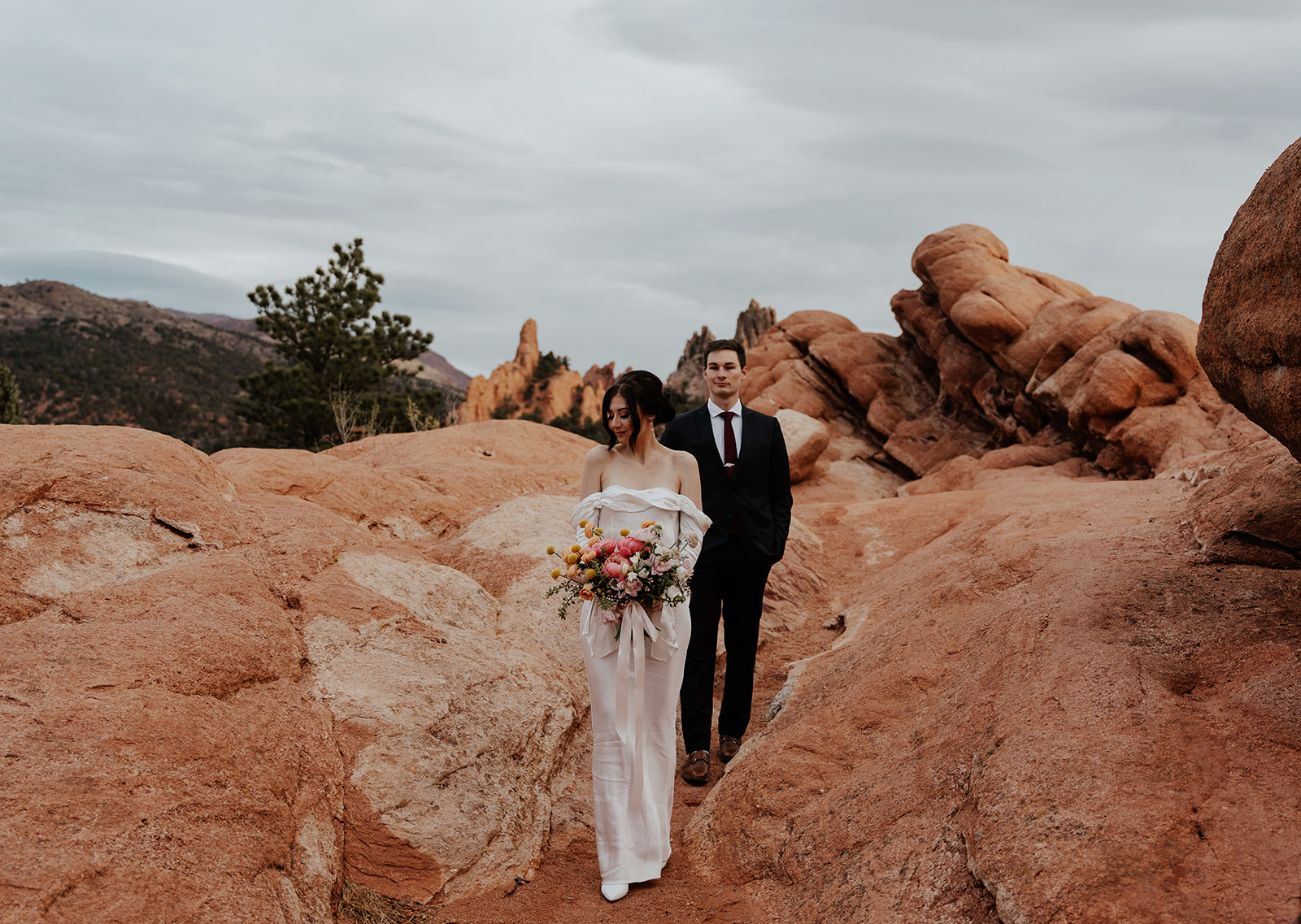 Bride and groom walking through the rocky landscapes of Garden of The Gods