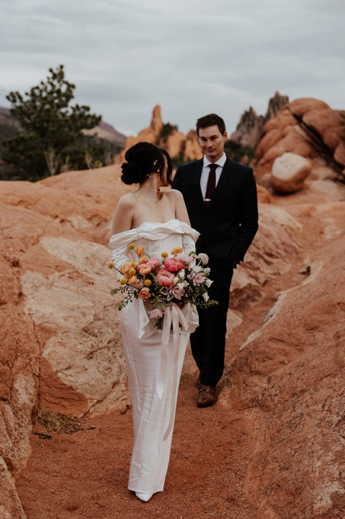 Bride and groom walking through the rocky landscape of Garden of The Gods