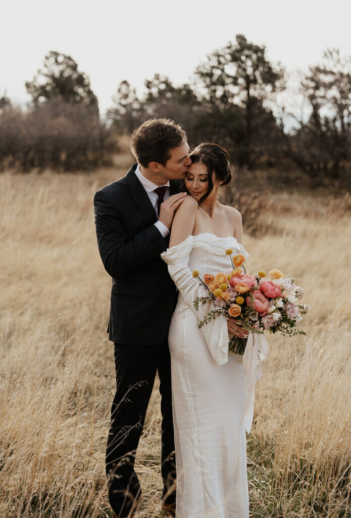 Groom kissing his bride on the cheek during their intimate elopement