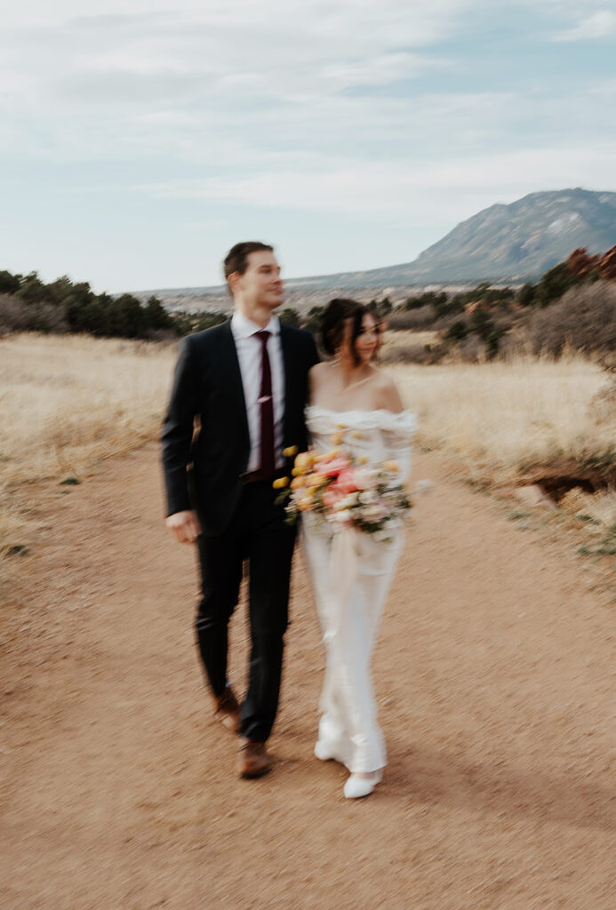 Blurry photo of a bride and groom walking a dirt path in Garden of The Gods