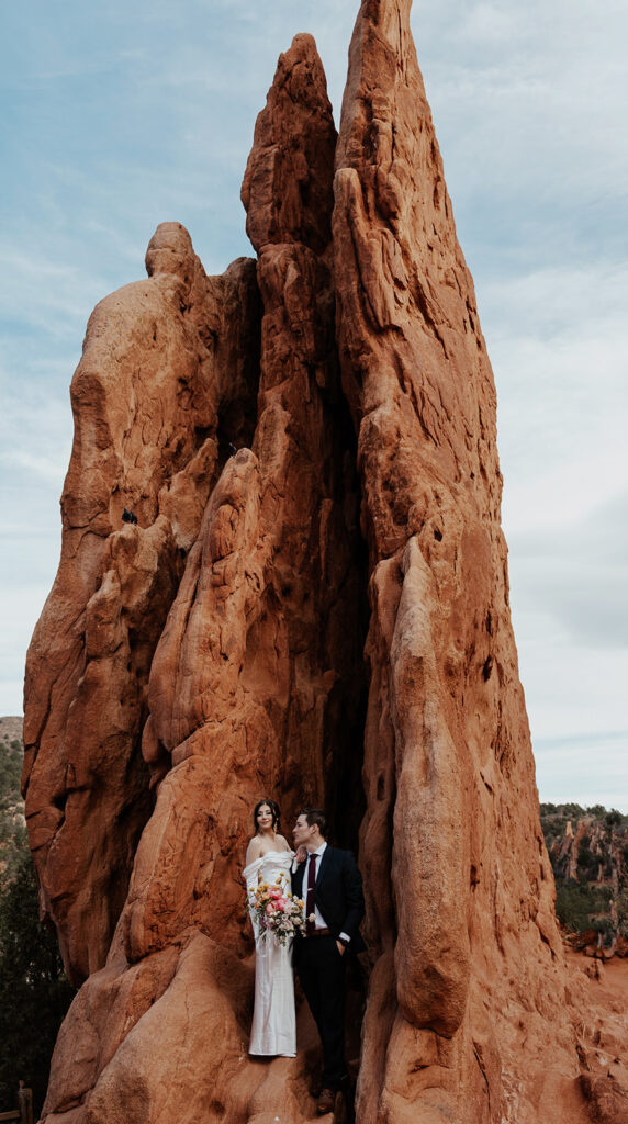 Bride and groom portraits in front of a large red rocks formation in Garden of The Gods