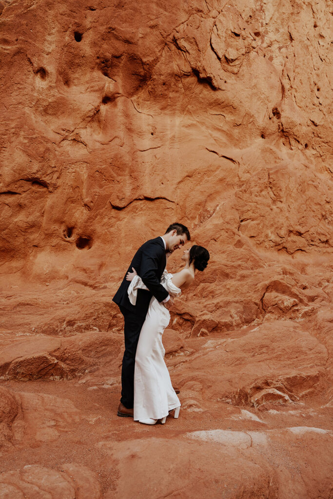 Bride and groom posing in front of the red rocks of Garden of The Gods in Colorado