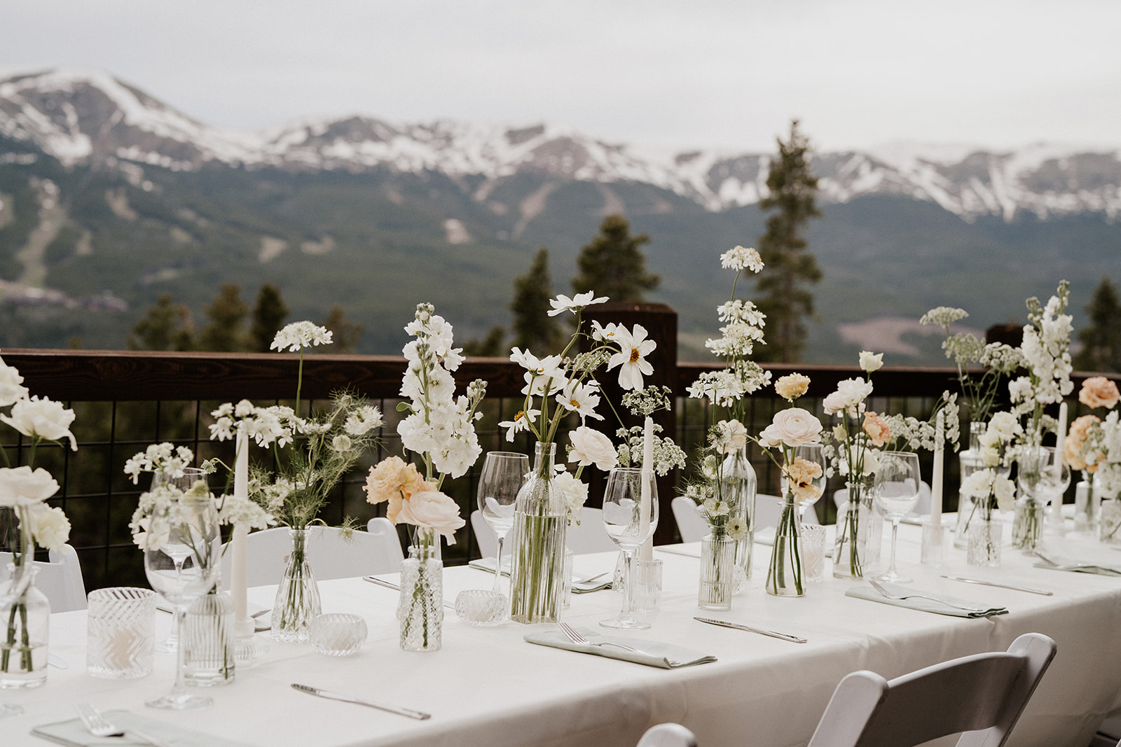 An outdoor Airbnb elopement reception with mountain backdrops in Breckenridge, Colorado at Northwoods with various white florals