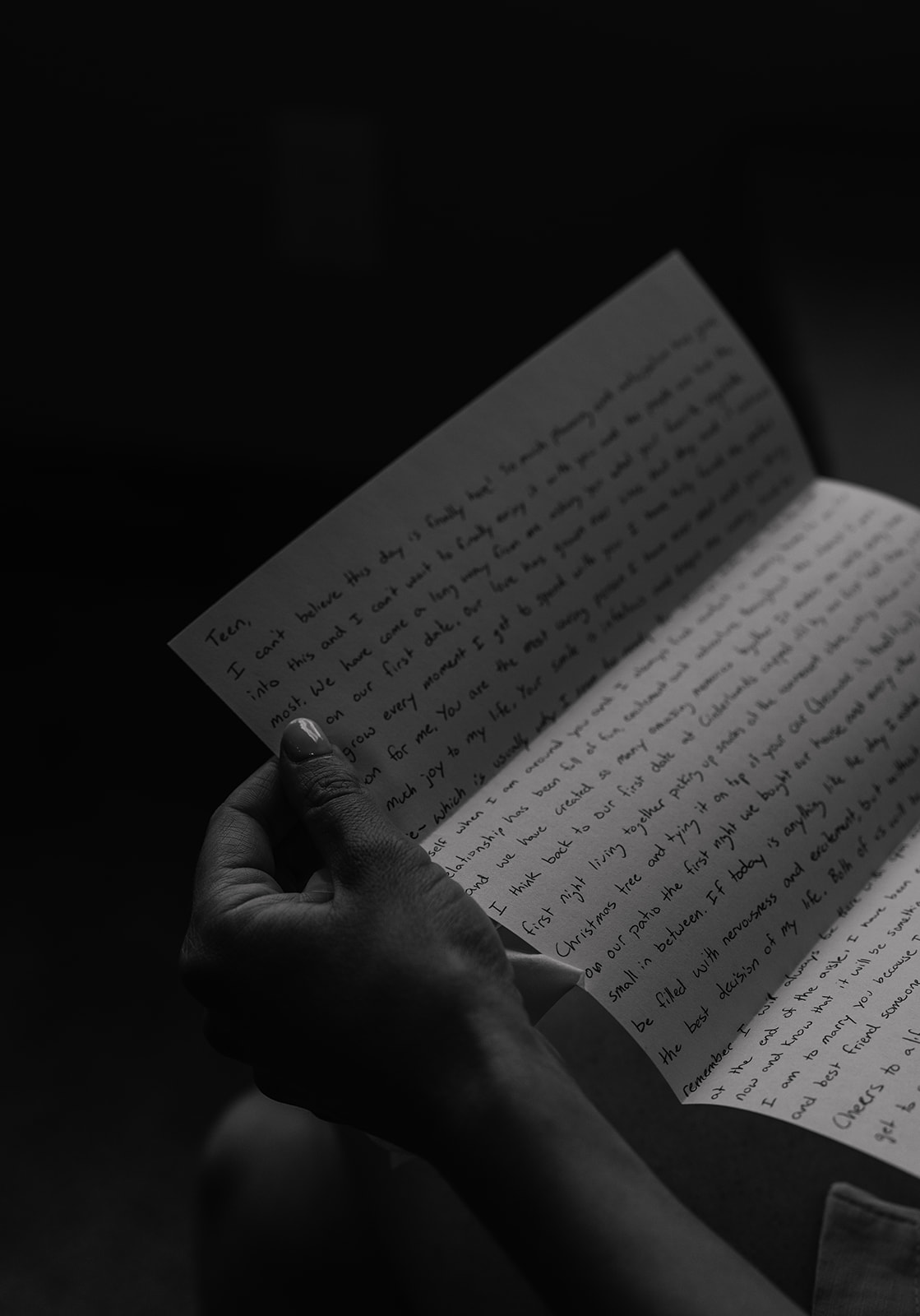 Black and white photo of a bride reading her letter from her soon to be husband