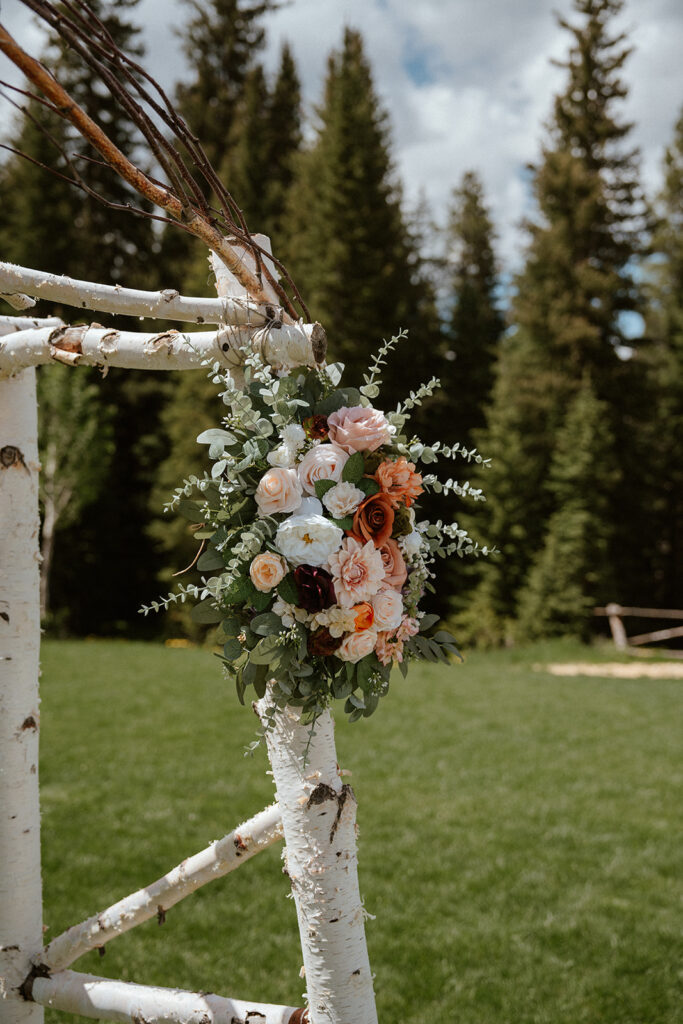 A wooden wedding arch with florals