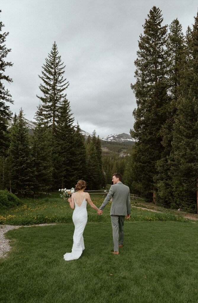 Bride and groom holding hands and walking during their Colorado mountain elopement