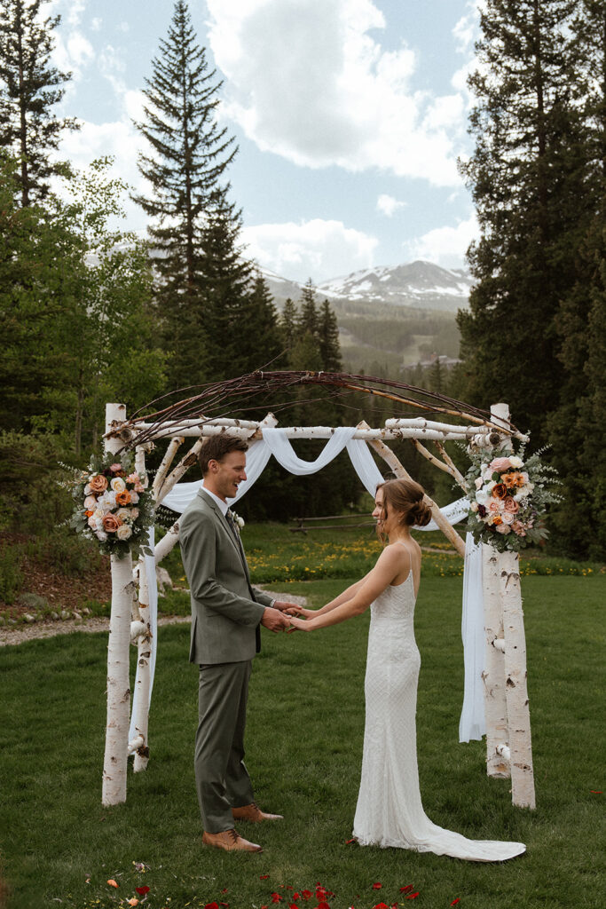 Bride and groom holding hands during their intimate wedding ceremony