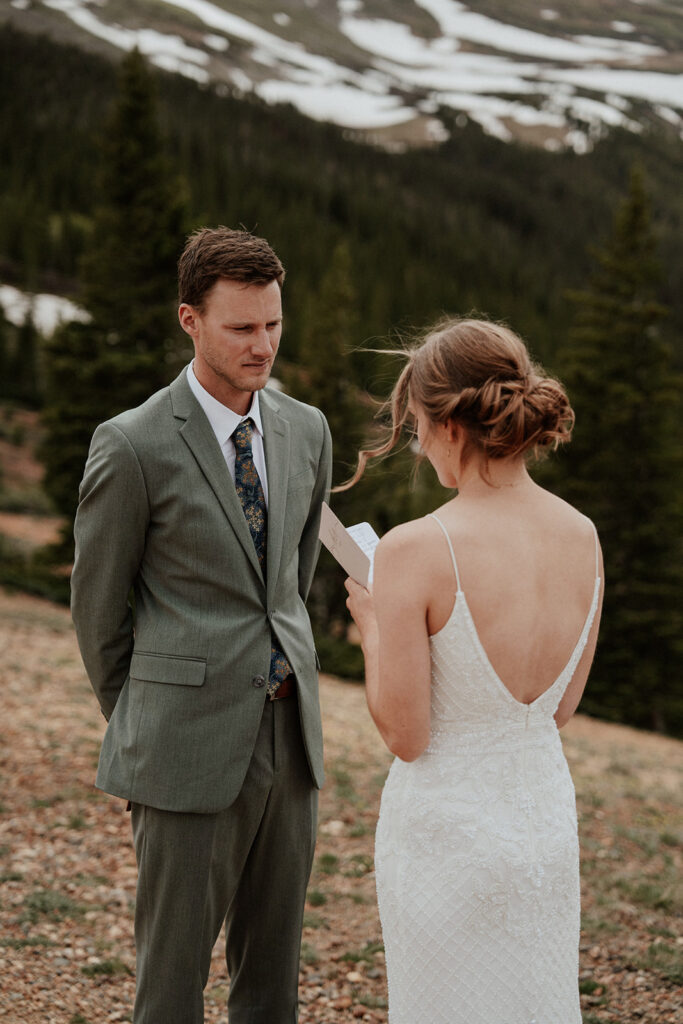 Bride reading her vows to her groom during their Colorado mountain elopement on Peak 9 in Breckenridge