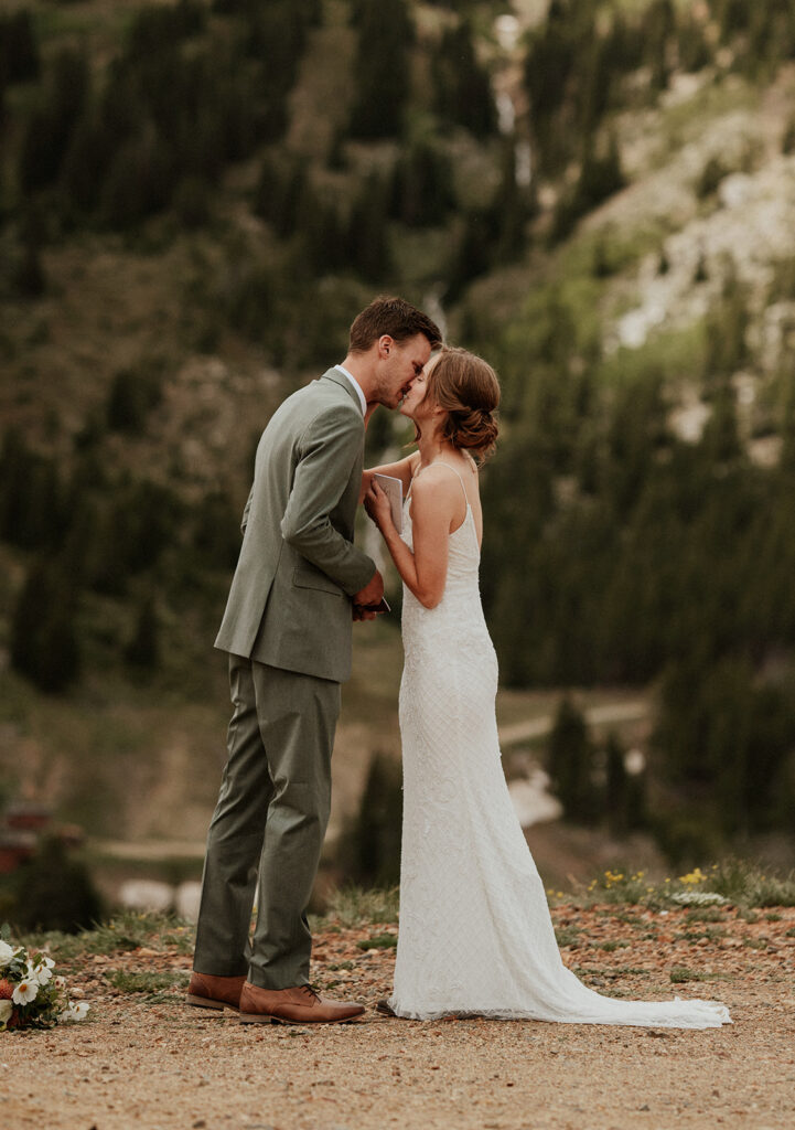 Bride and groom kissing during their private vows on Peak 9 in Breckenridge