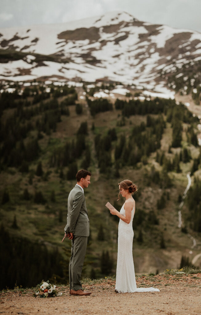 Bride reading her vows to her groom during their Colorado mountain elopement on Peak 9 in Breckenridge