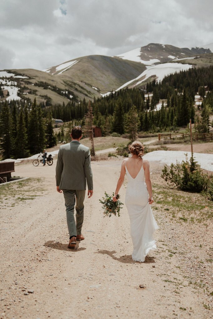 Bride and groom walking back down a mountain together during their Colorado elopement in Breckenridge