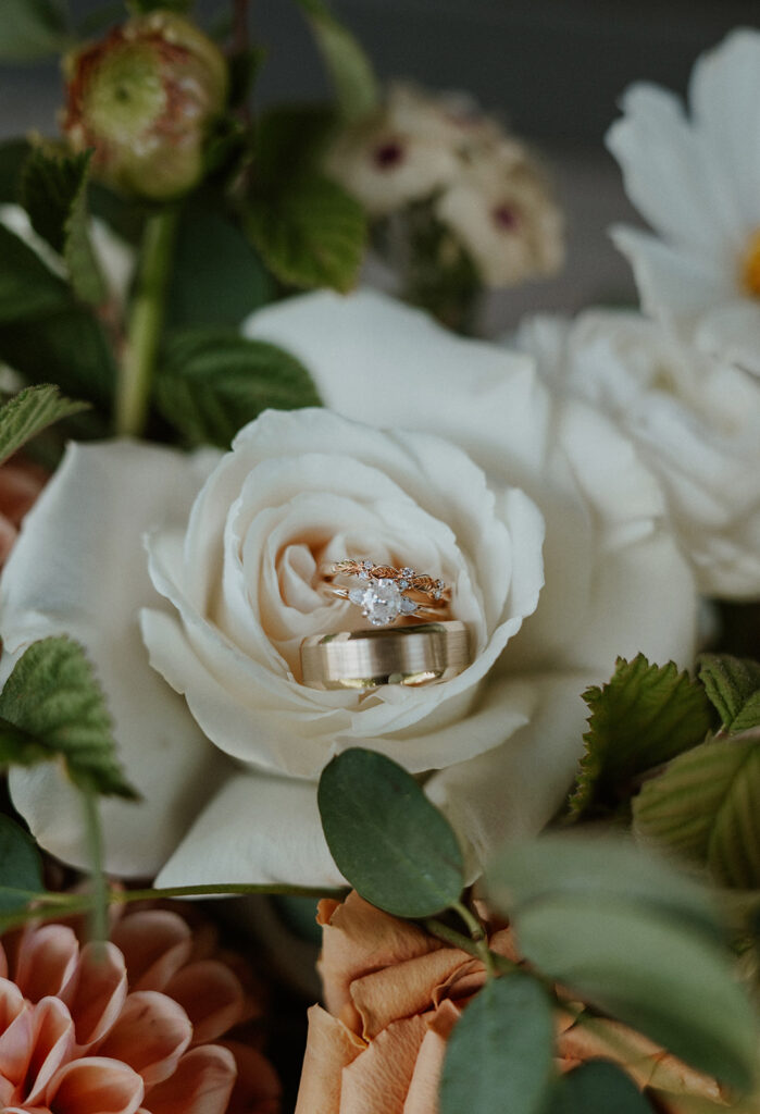 Detail shot of a brides ring and grooms band in a bouquet of flowers