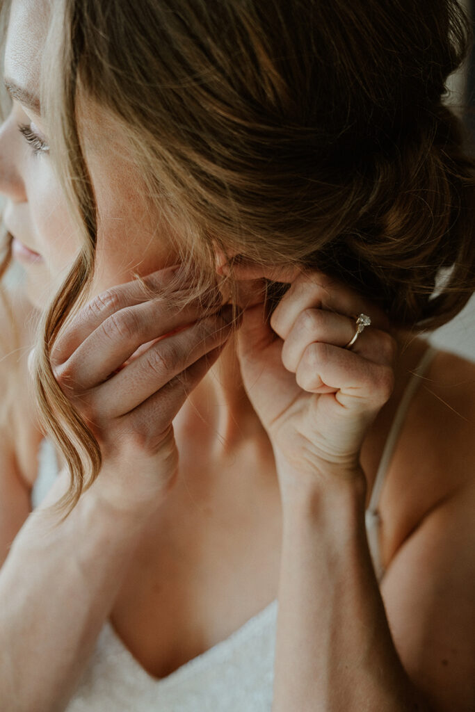 Bride putting her earrings in