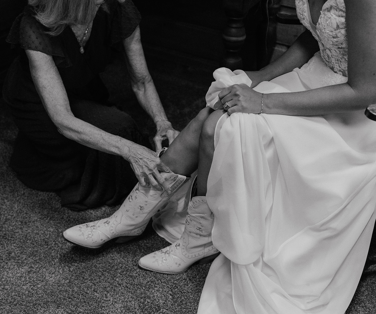 Black and white photo of a mother putting on her daughters boots for her Hoosier Pass elopement in Colorado