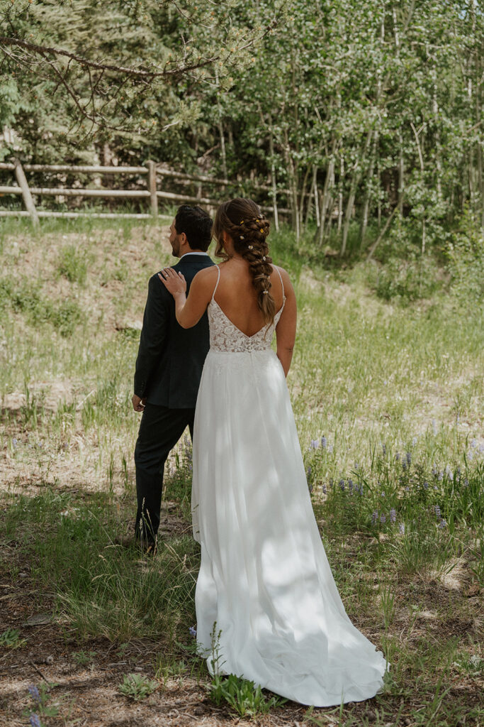 Bride tapping her grooms shoulder as they're about to share a first look