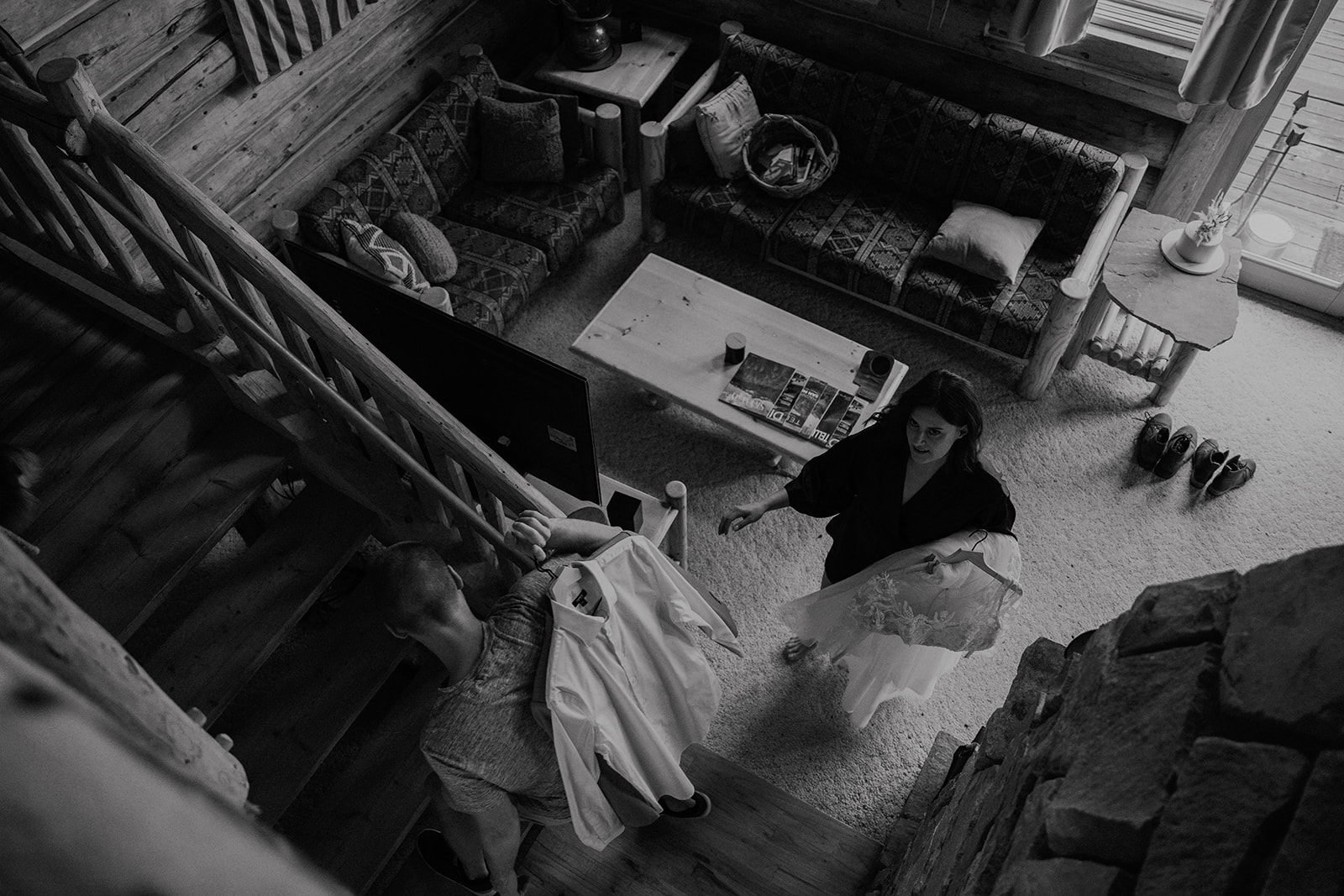 Black and white candid photo of a bride and groom going upstairs to get ready for their elopement