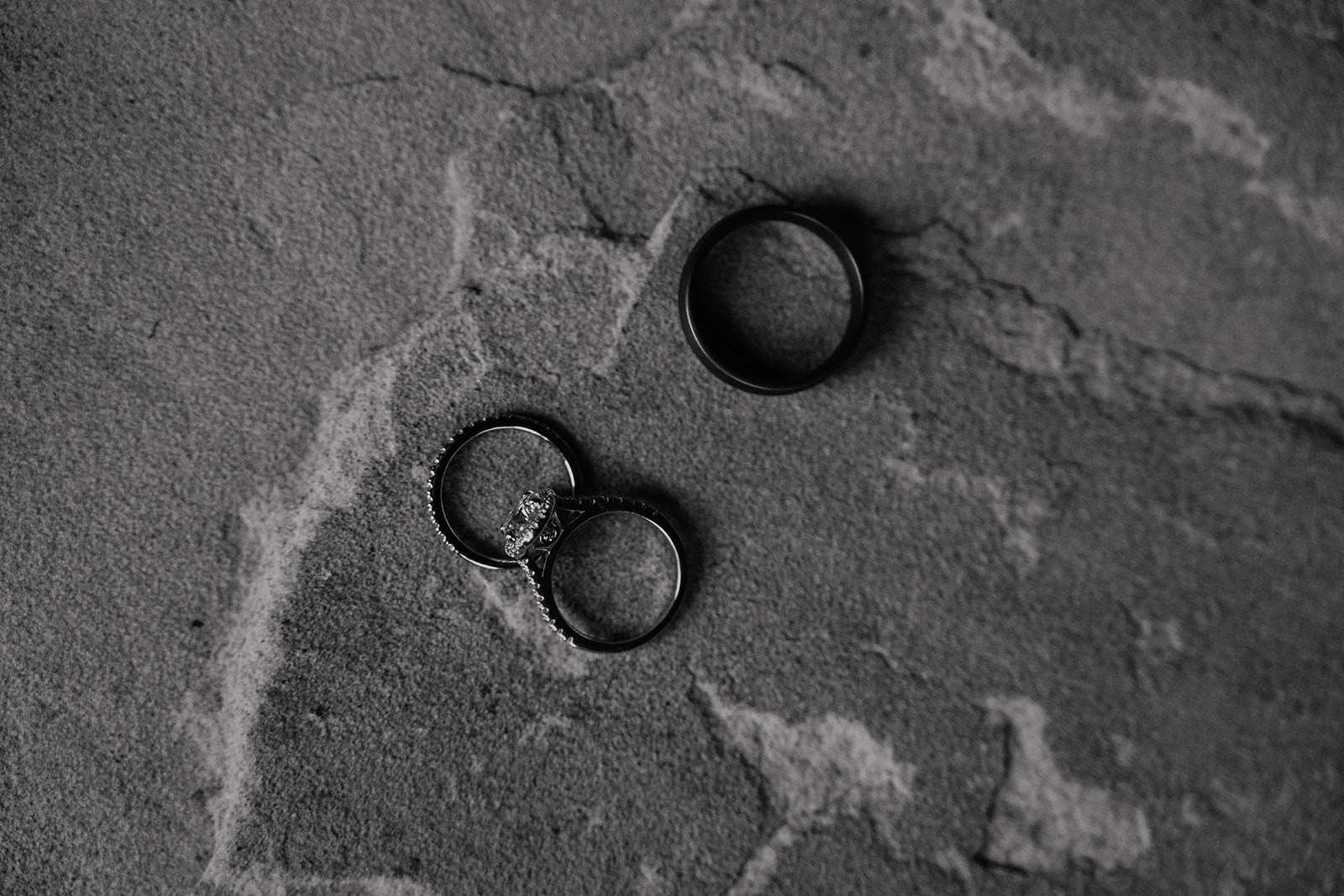 Black and white photo of a brides rings and grooms wedding band