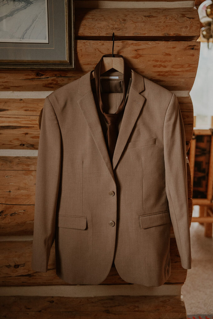 Grooms brown suit hanging in their Telluride, Colorado cabin