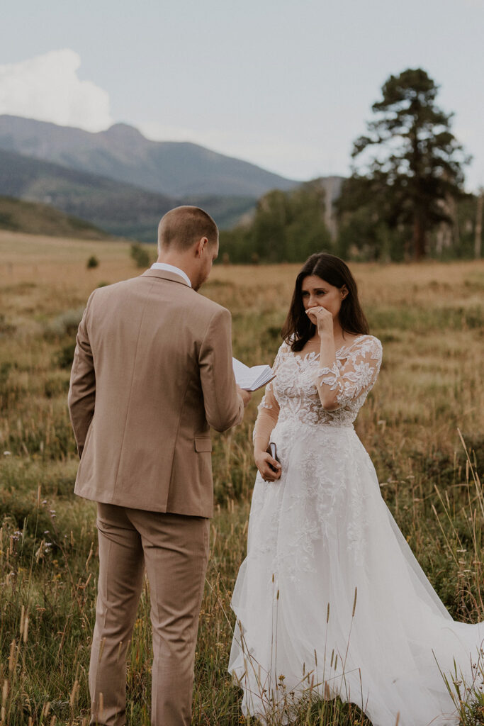 Bride getting emotional as her groom reads his vows to her