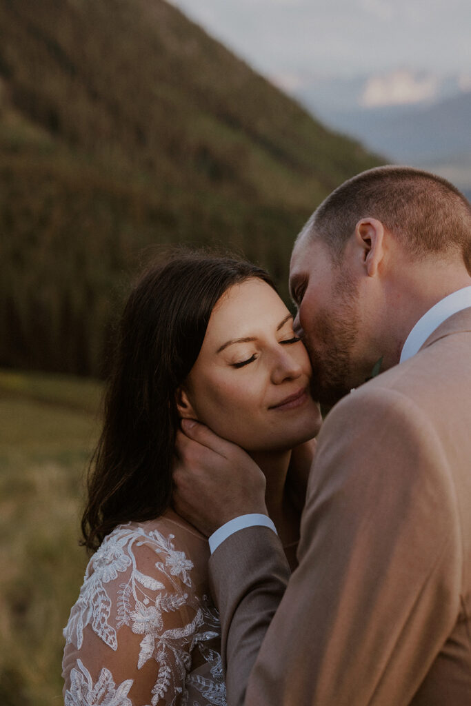 Groom kissing his bride on the cheek