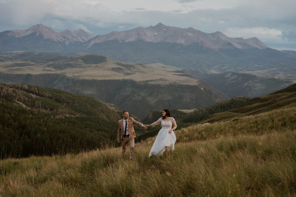 Bride and groom walking through the Colorado mountains