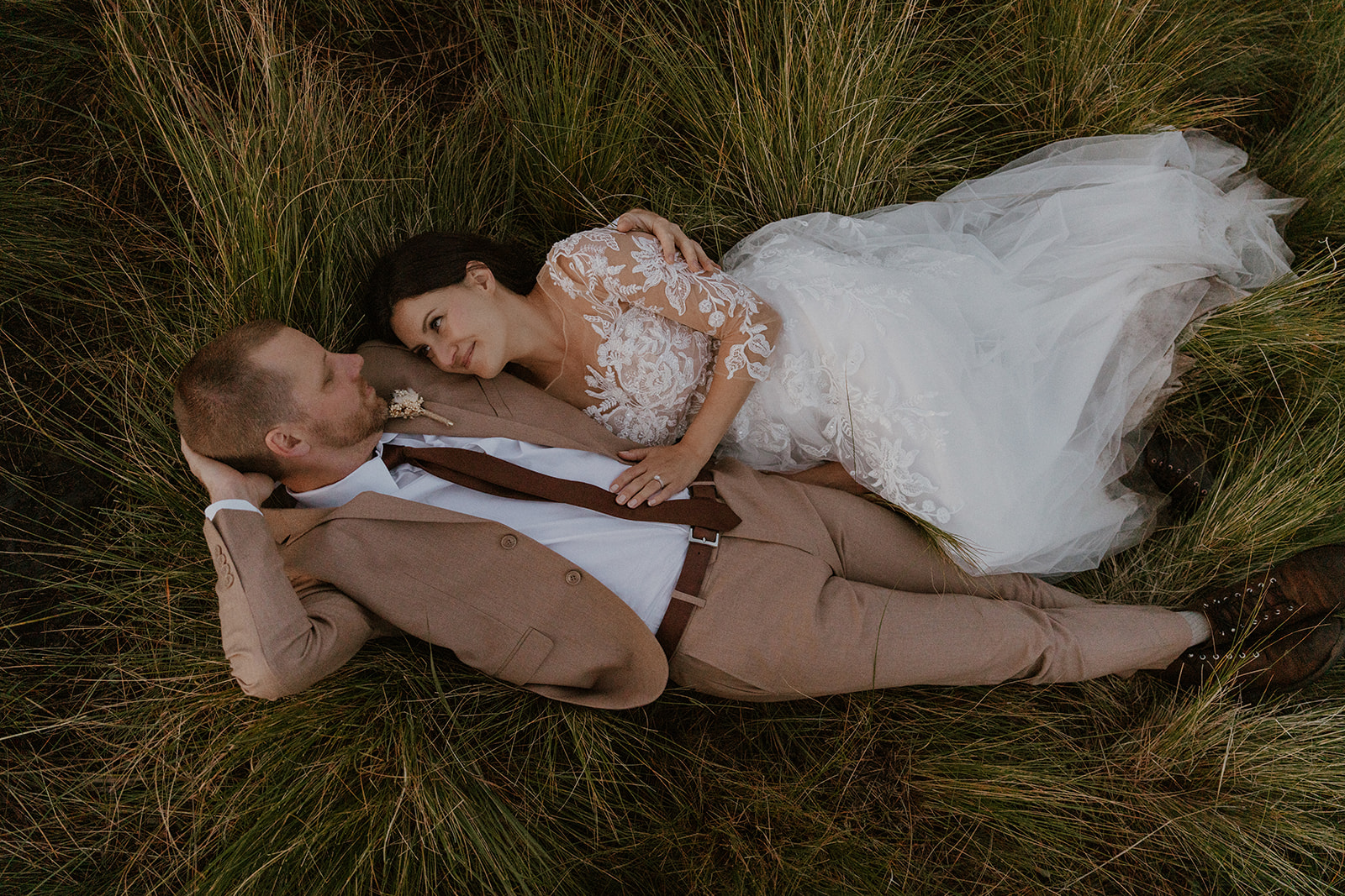 Bride and groom laying in the grass during their Colorado elopement