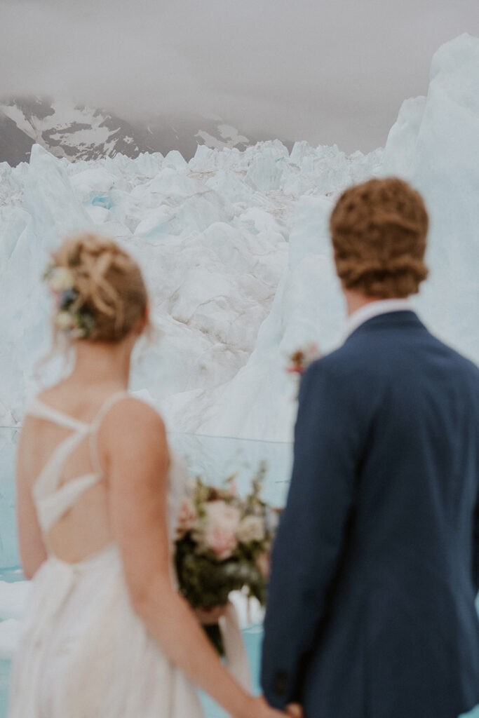 Bride and groom eloping in Alaska and admiring the glaciers