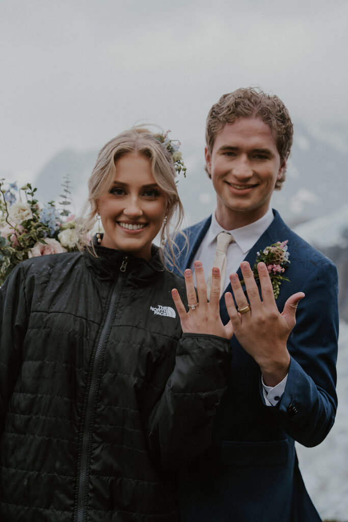 Bride and groom showing off their wedding rings after eloping in Alaska