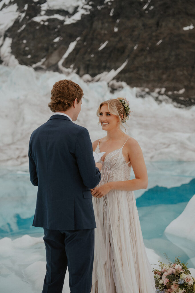 Groom exchanging his vows to his bride at Knik Glacier