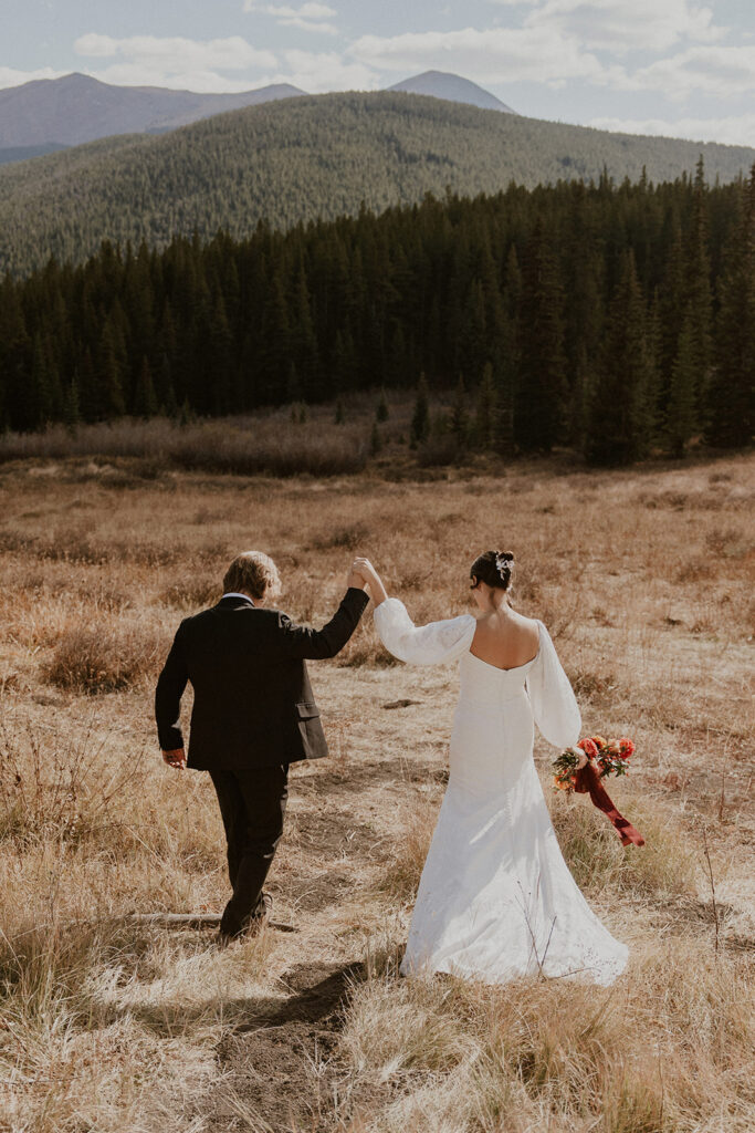 Bride and groom walking in a field for their Colorado elopement