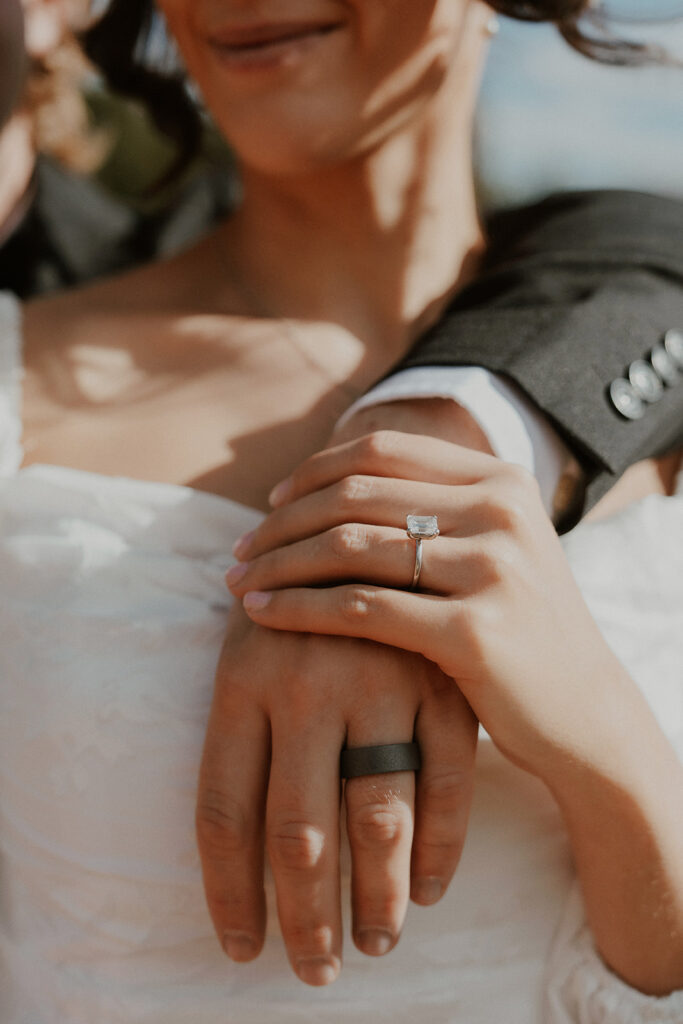 Close up shot of a bride and groom showing off their wedding rings