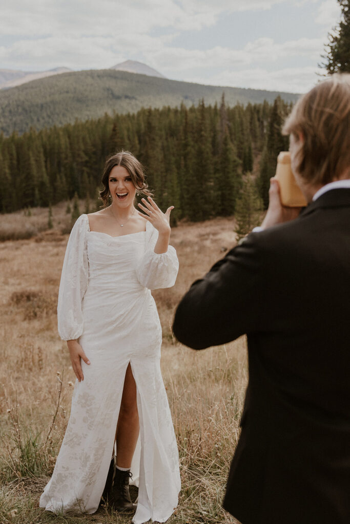 Groom taking a polaroid photo of a bride showing off her wedding ring