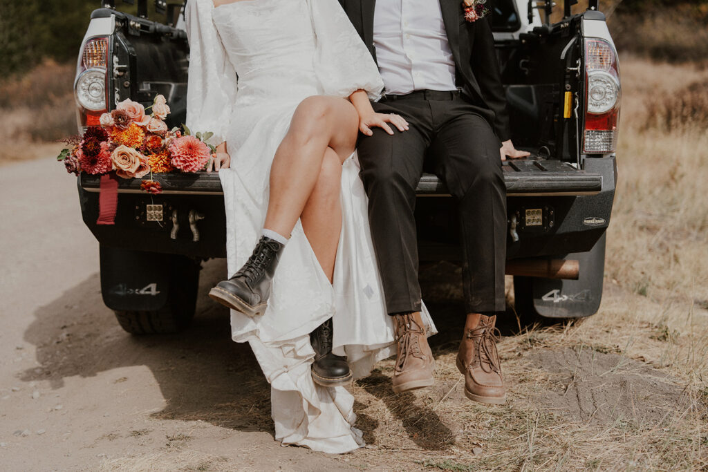 Bride and groom sitting in the back of their pickup truck during their Boreas Pass Colorado elopement