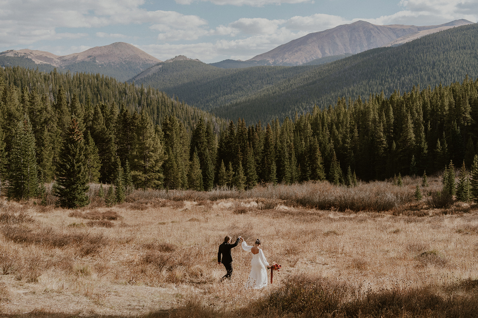 Bride and groom walking through the Breckenridge mountains during their Boreas Pass elopement