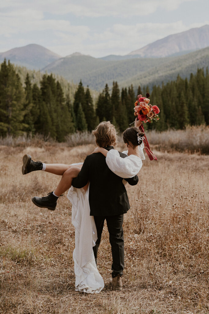 Groom carrying his bride during their Boreas Pass Colorado elopement portraits