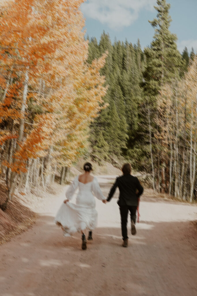 Blurry elopement photo of a bride and groom running down Boreas Pass in Colorado