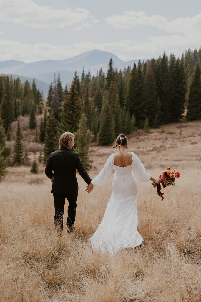 Bride and groom holding hands as they walk out to their ceremony location