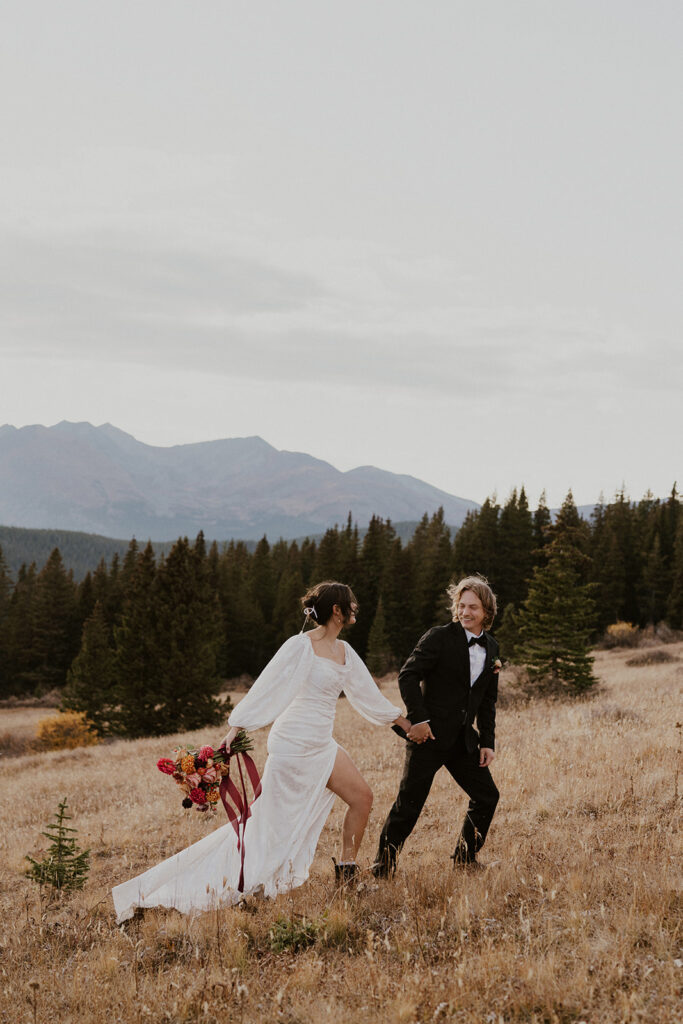 Bride and groom walking up the mountains in Breckenridge 