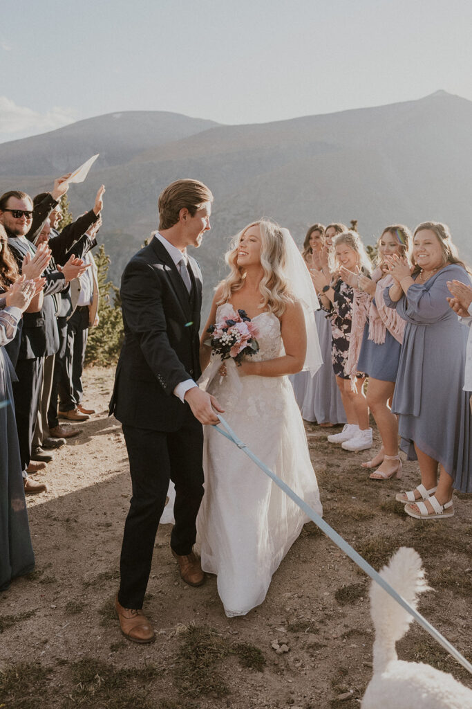 Bride and groom walking back down the aisle with their dog after their intimate Breckenridge wedding ceremony at Hoosier Pass