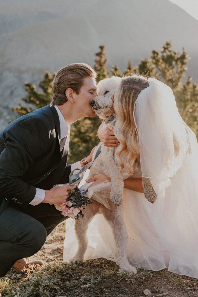 Bride and groom kissing their dog during their elopement photos