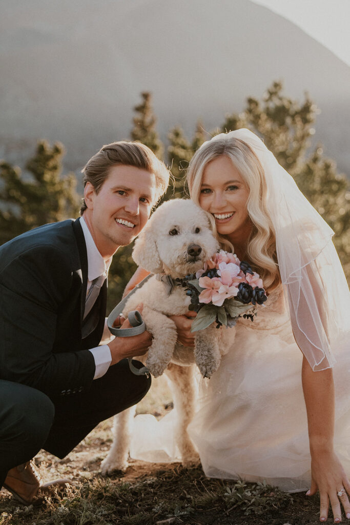 Bride and groom posing with their dog for their elopement photos