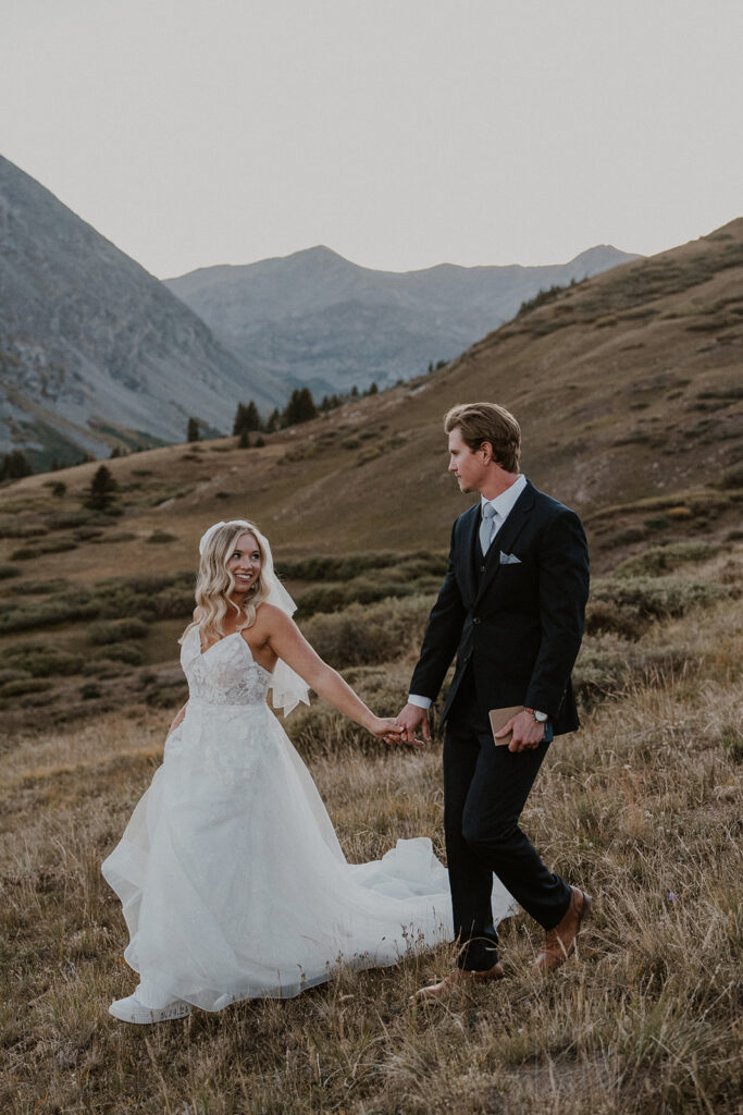 Bride and groom walking in the Colorado mountains for their intimate Breckenridge wedding portraits