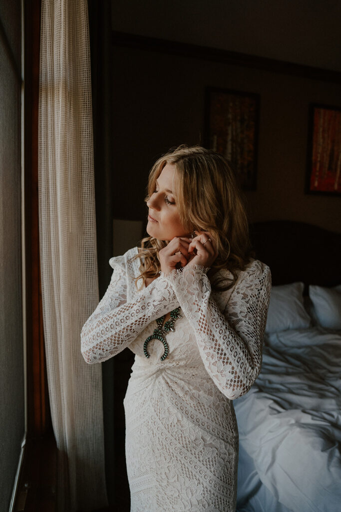 Bride putting her earrings in for her Aspen, Colorado elopement