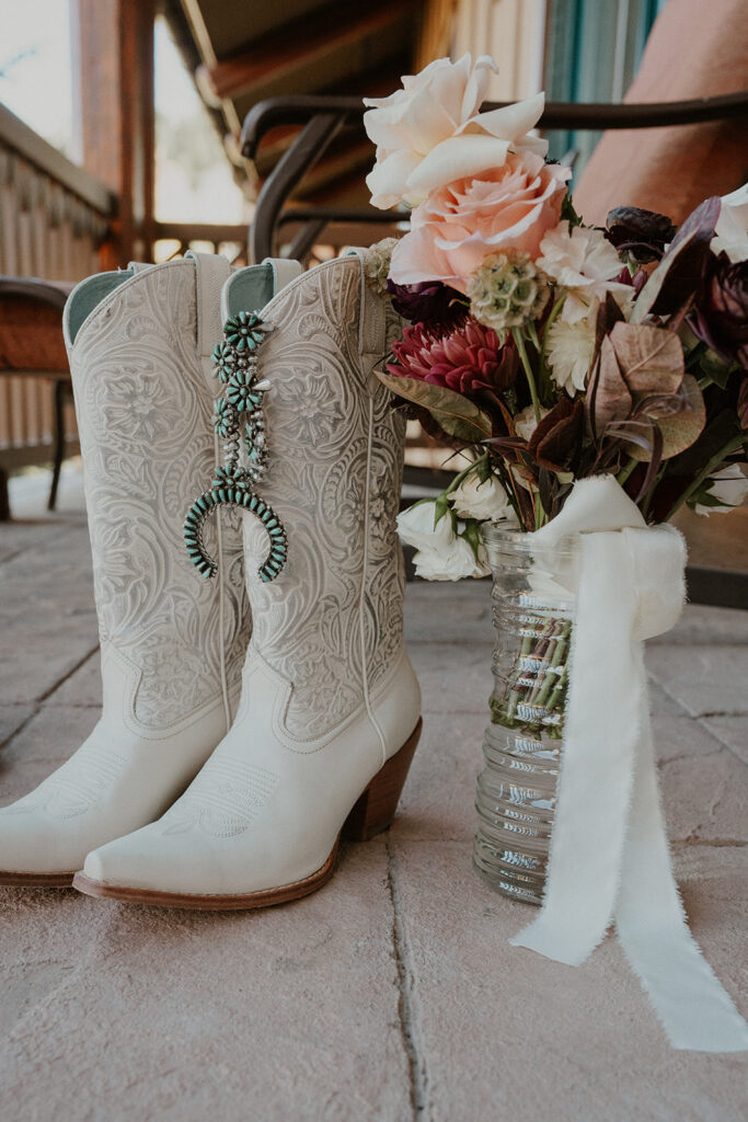 Brides wedding details with cowgirl boots, jewelry, and a wedding bouquet from an Aspen, Colorado elopement.